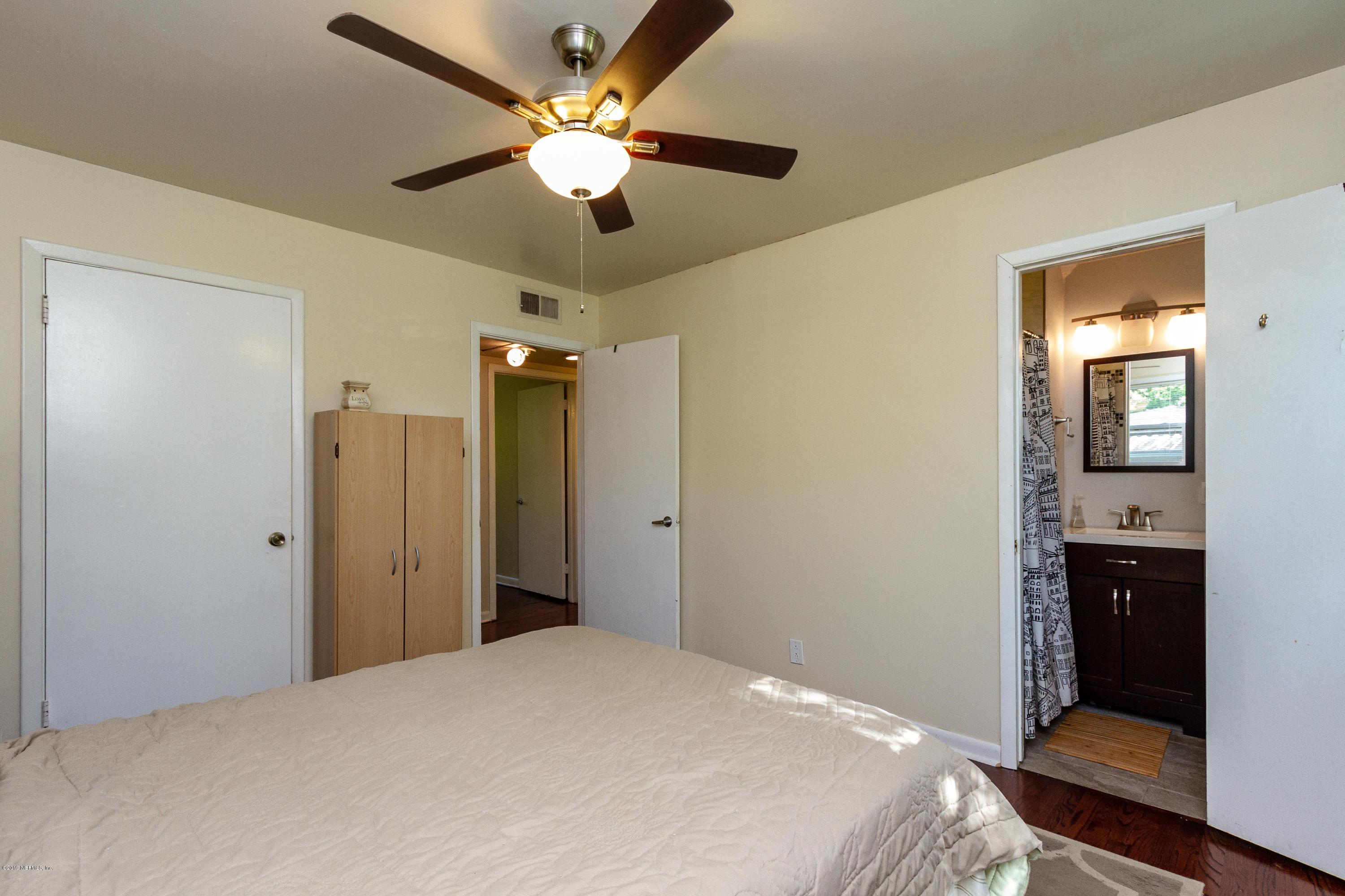 7420 Hennessy Road Jacksonville, FL 32244 - Photo 24 of 39 a bedroom with a bed and a chandelier