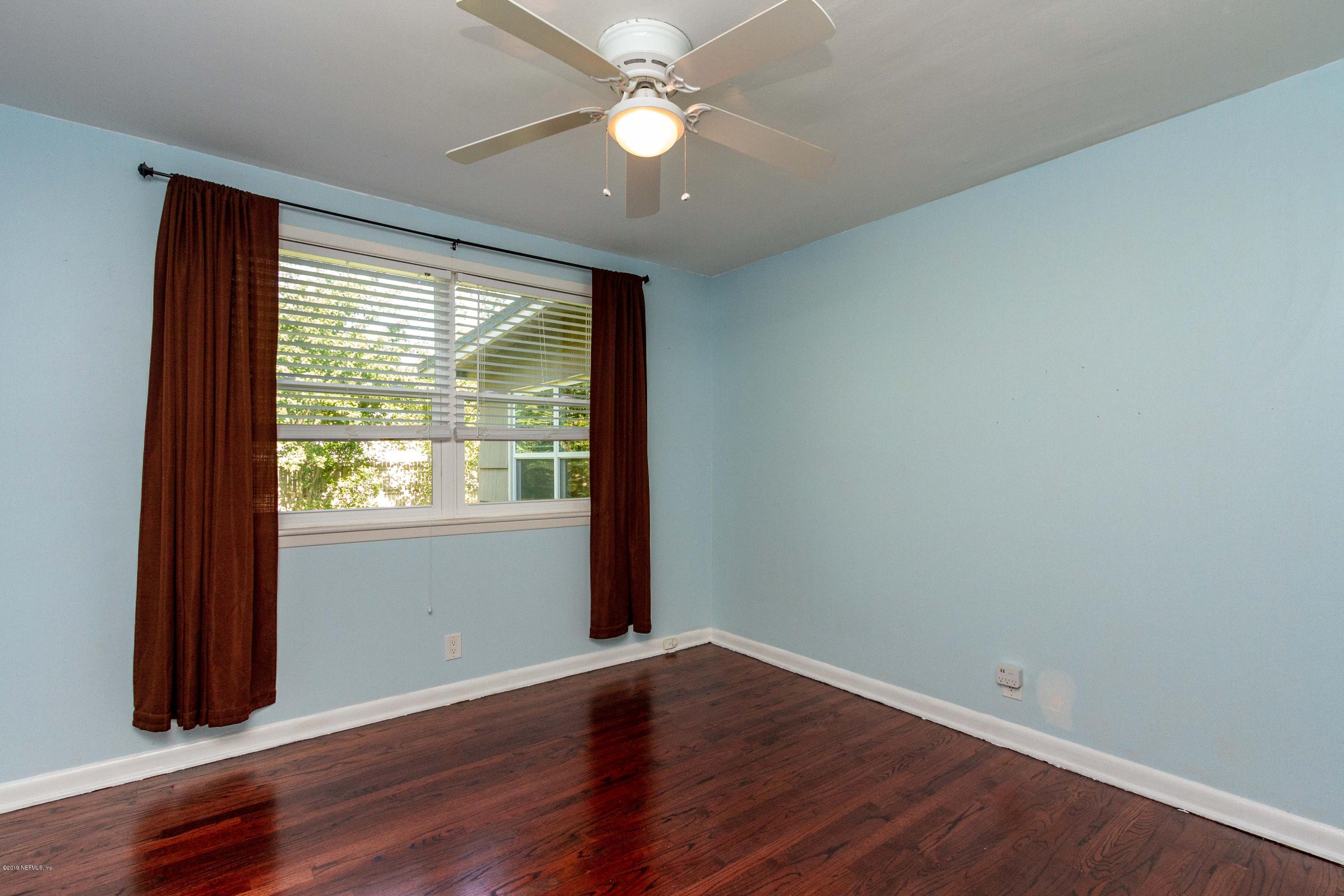 7420 Hennessy Road Jacksonville, FL 32244 - Photo 27 of 39 an empty room with wooden floor and windows