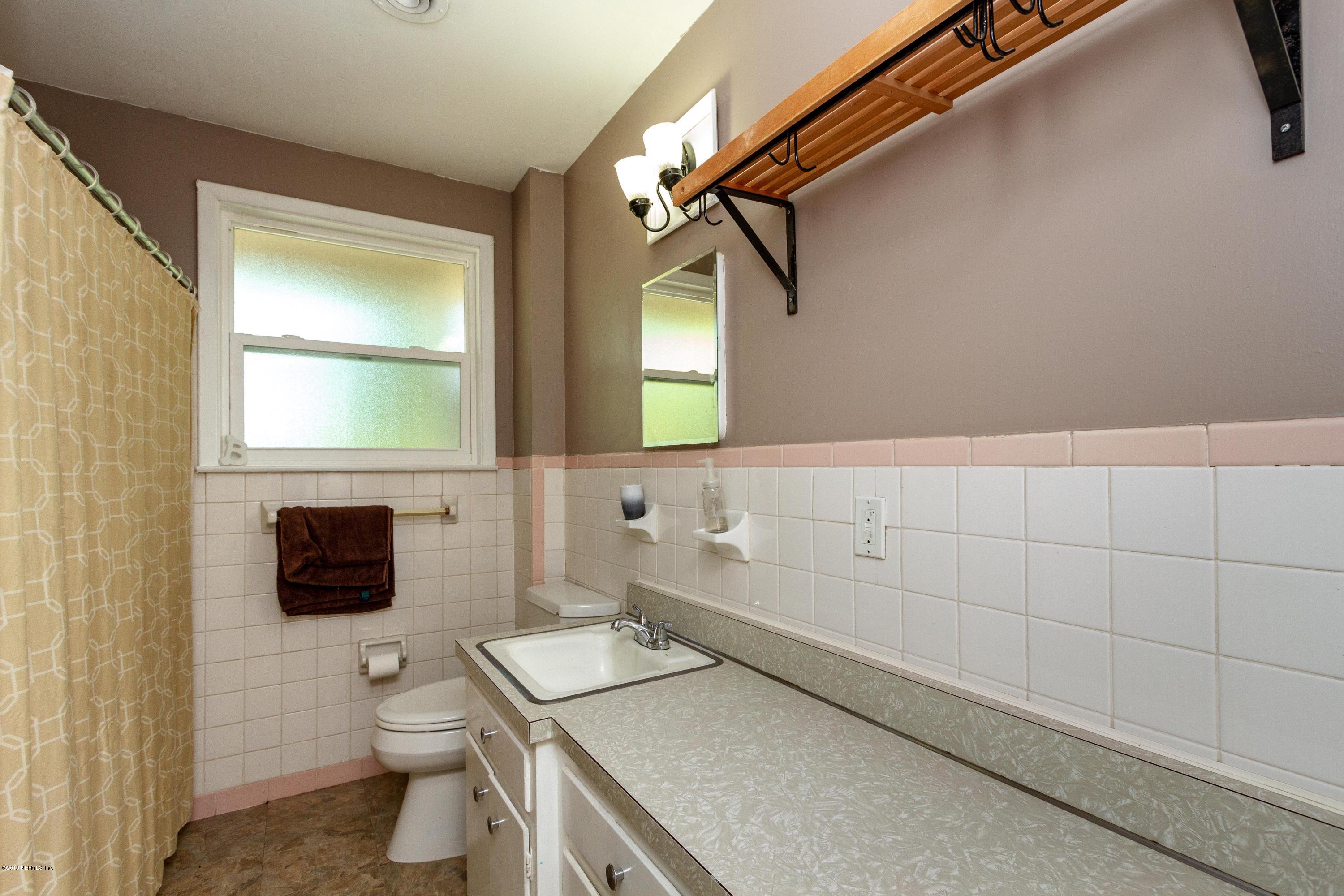 7420 Hennessy Road Jacksonville, FL 32244 - Photo 28 of 39 a bathroom with a granite countertop toilet sink and mirror