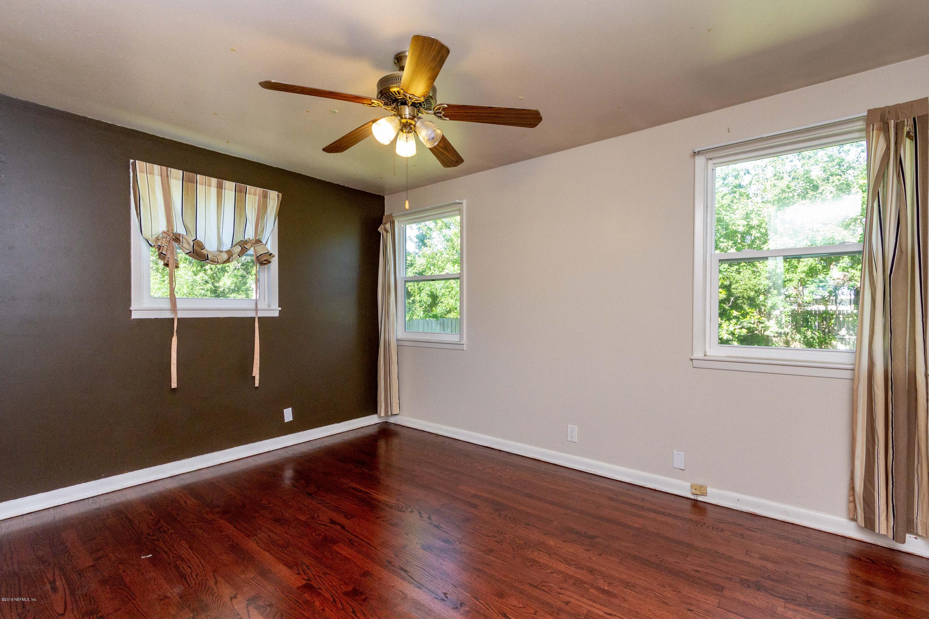 7420 Hennessy Road Jacksonville, FL 32244 - Photo 29 of 39 a view of room with window ceiling fan and hardwood floor