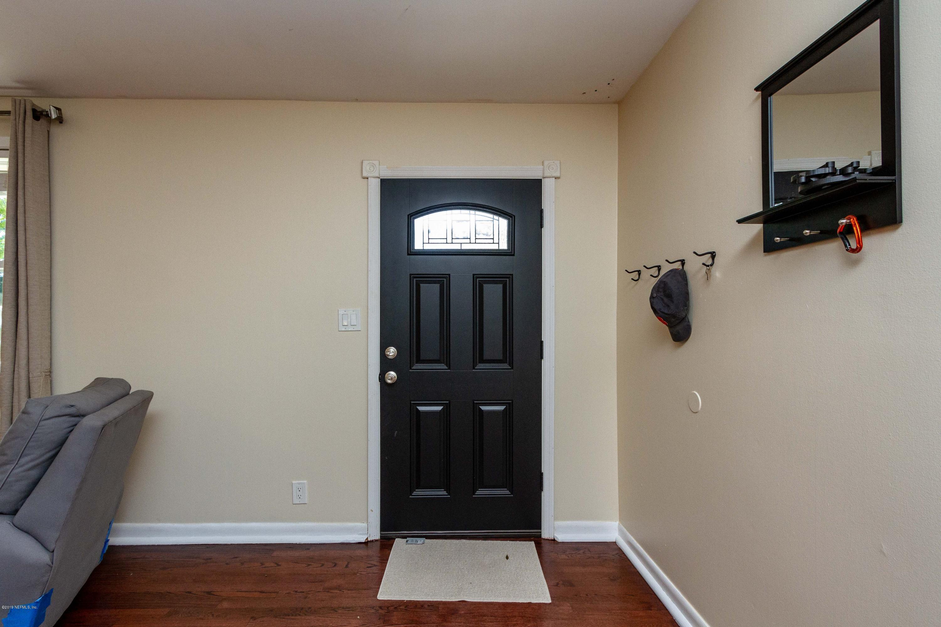7420 Hennessy Road Jacksonville, FL 32244 - Photo 6 of 39 a view of a hallway with wooden floor and windows