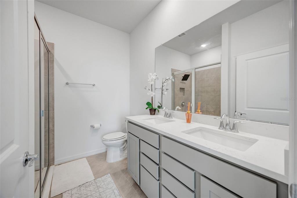 2555 Bending Bonsai Drive Wesley Chapel, FL 33543 - Photo 14 of 59 a bathroom with a granite countertop sink a toilet and a large mirror