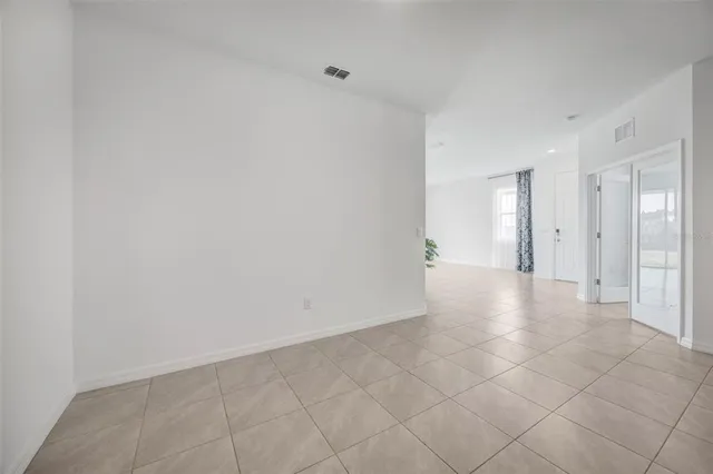 a large white kitchen with kitchen island a stove a sink a refrigerator and white cabinets