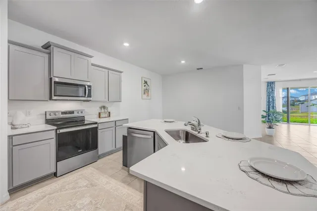 a kitchen with a sink a counter top space stainless steel appliances and cabinets