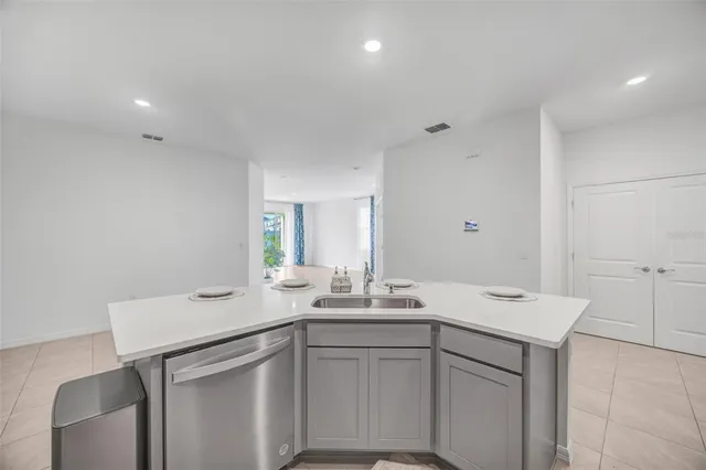 a kitchen with stainless steel appliances a sink a stove a microwave a center island and cabinets