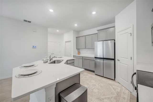 an empty room with ceiling fan and windows