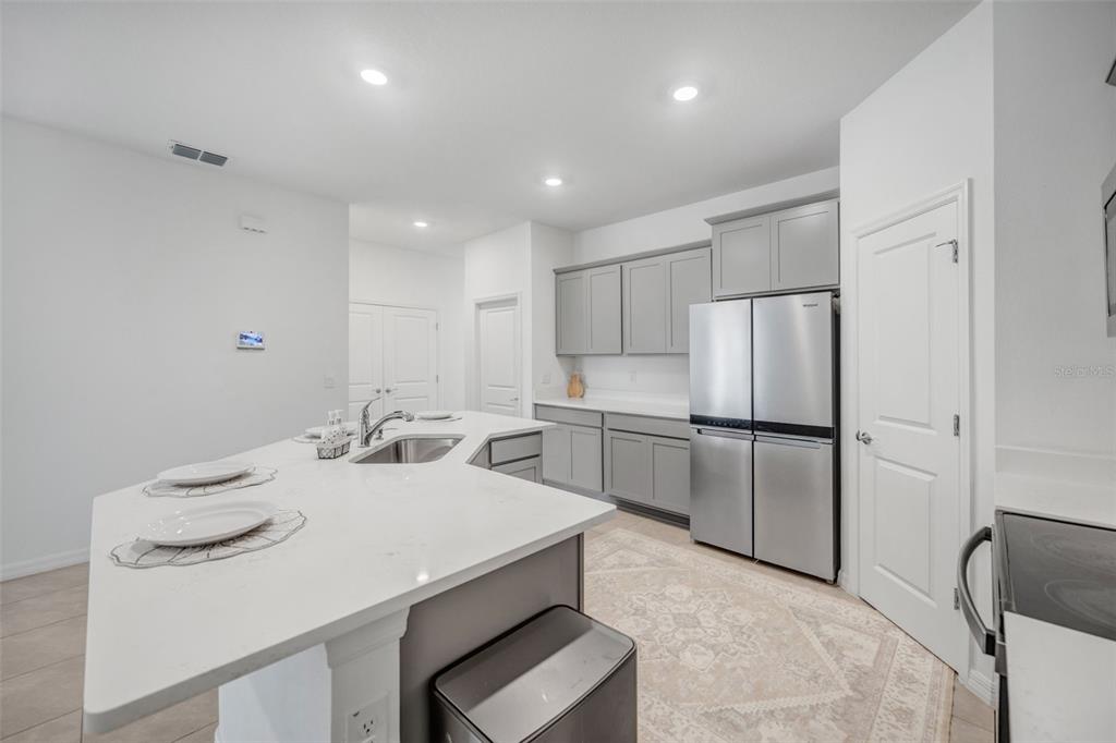 2555 Bending Bonsai Drive Wesley Chapel, FL 33543 - Photo 38 of 59 a kitchen with a sink a stove a refrigerator and white cabinets