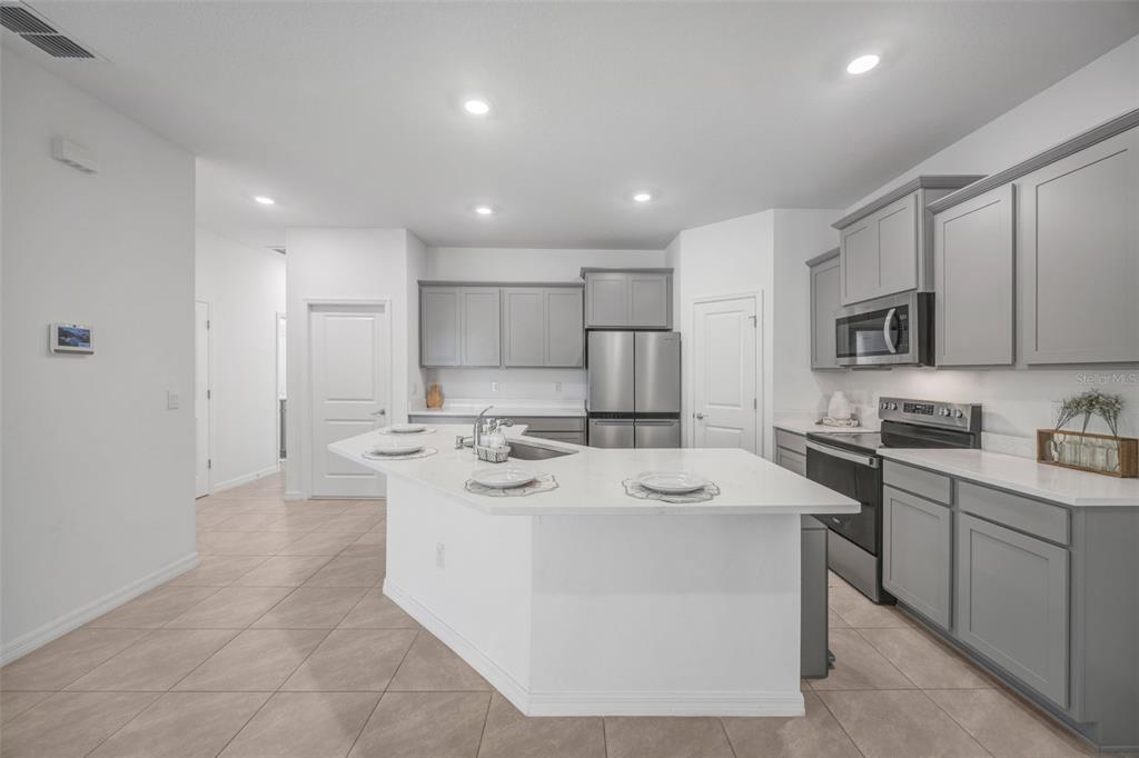 2555 Bending Bonsai Drive Wesley Chapel, FL 33543 - Photo 39 of 59 a kitchen with stainless steel appliances granite countertop a sink stove refrigerator and cabinets