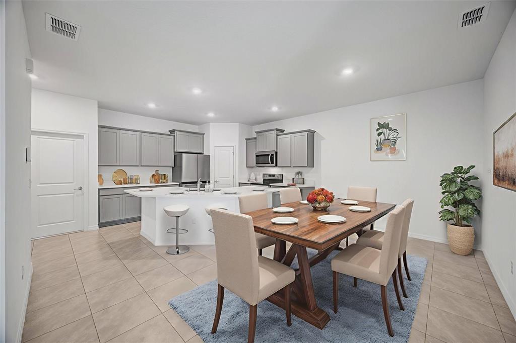 2555 Bending Bonsai Drive Wesley Chapel, FL 33543 - Photo 41 of 59 a kitchen with a dining table chairs and refrigerator