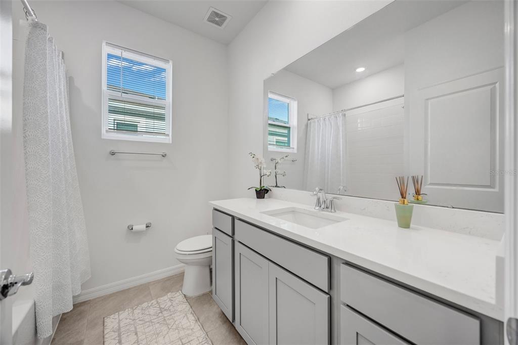 2555 Bending Bonsai Drive Wesley Chapel, FL 33543 - Photo 51 of 59 a bathroom with a granite countertop sink toilet and mirror
