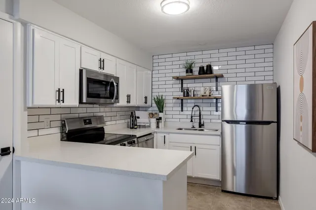 a kitchen with stainless steel appliances a refrigerator stove microwave and sink