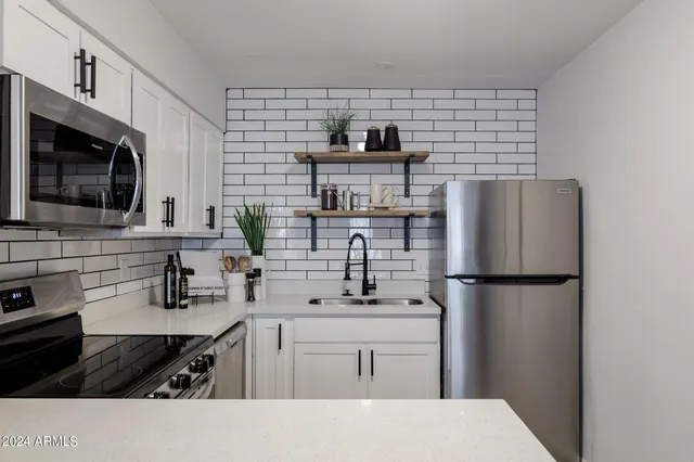 a kitchen with a refrigerator and a stove top oven
