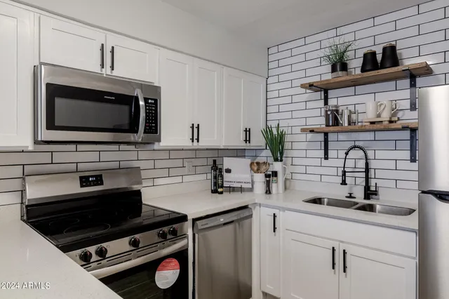 a kitchen with appliances a sink and a cabinets