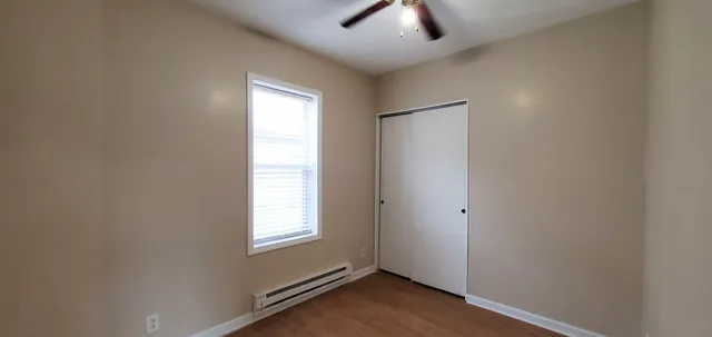 an empty room with windows and fan