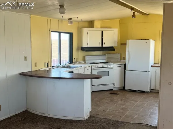a kitchen with stainless steel appliances granite countertop a sink a stove a refrigerator a washer and dryer