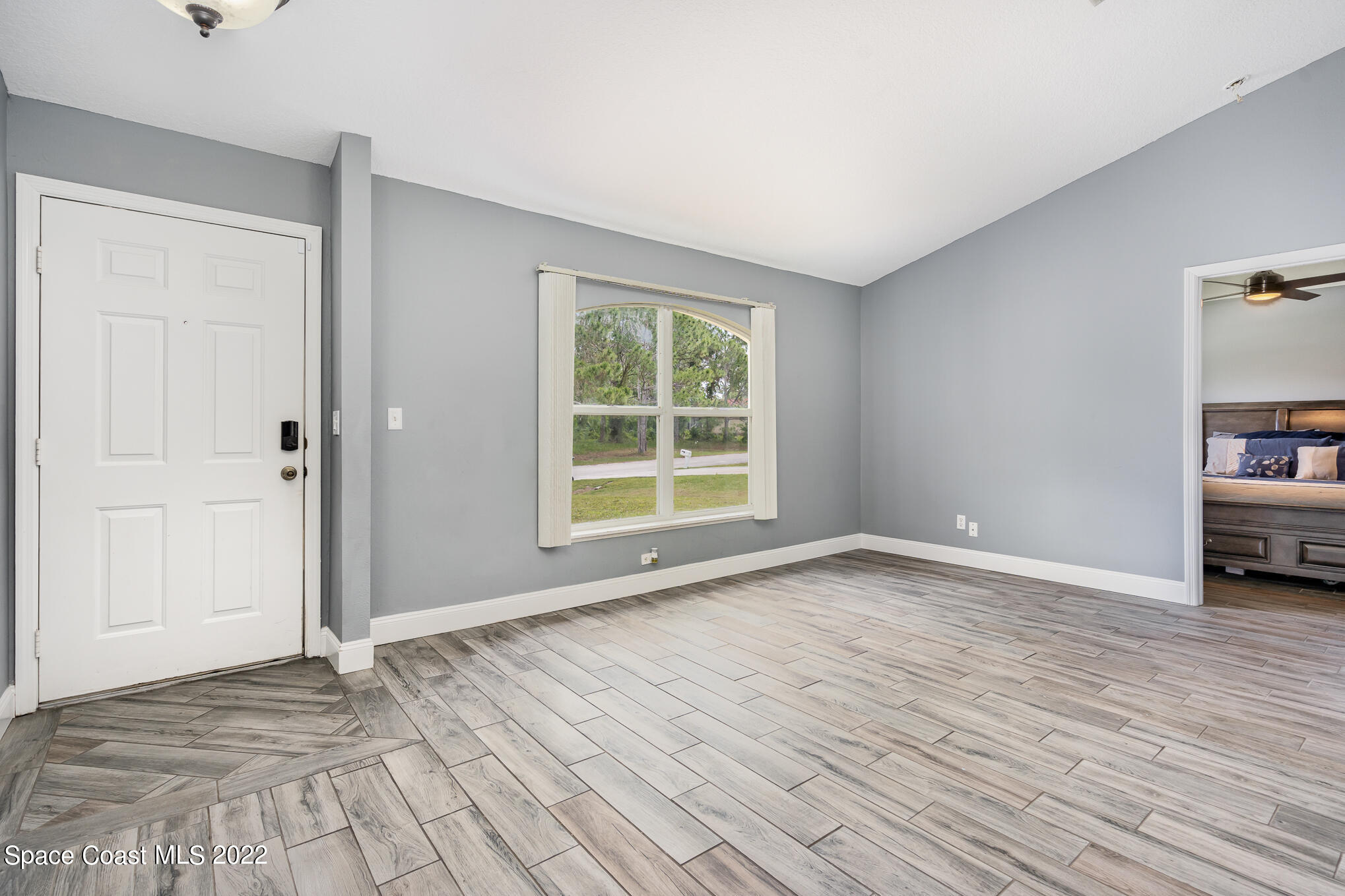 1290 Daton Road Southwest Palm Bay, FL 32908 - Photo 13 of 29 a view of an empty room with window and wooden floor