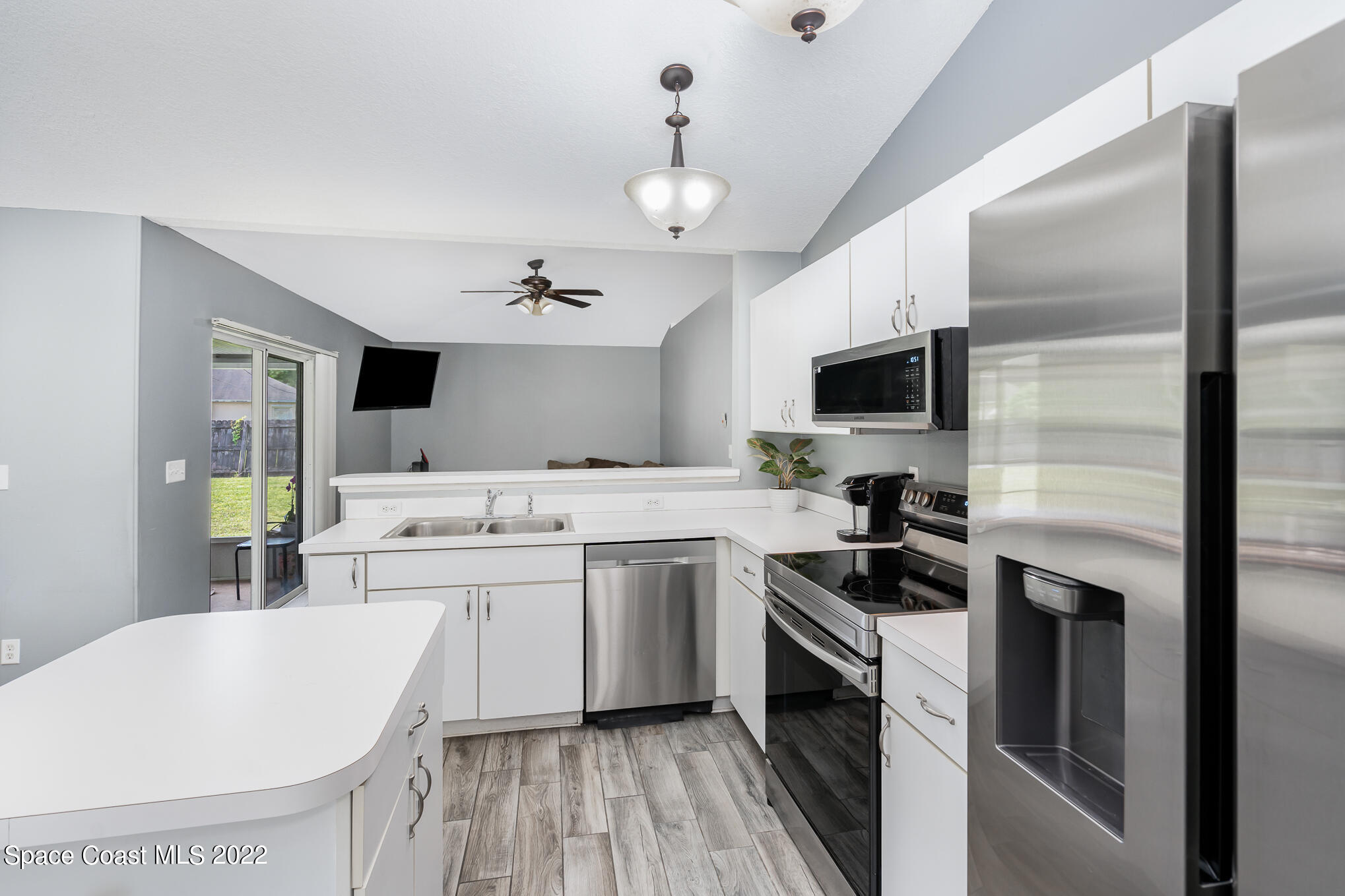 1290 Daton Road Southwest Palm Bay, FL 32908 - Photo 18 of 29 a kitchen with a sink stainless steel appliances and white cabinets