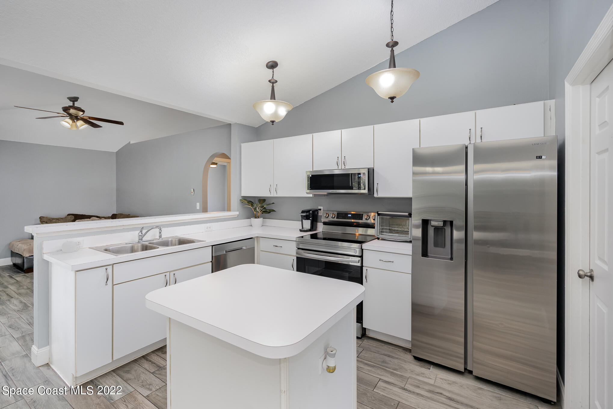 1290 Daton Road Southwest Palm Bay, FL 32908 - Photo 19 of 29 a kitchen with white cabinets and stainless steel appliances
