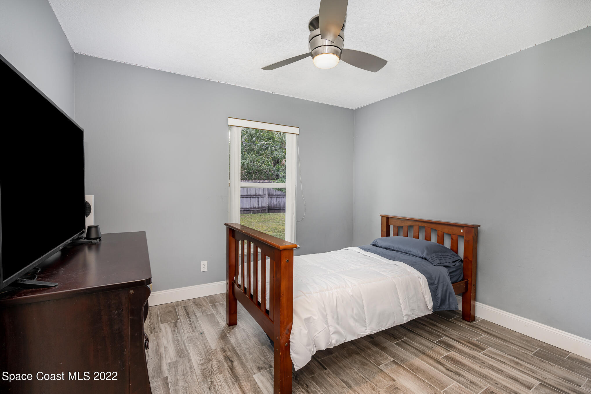 1290 Daton Road Southwest Palm Bay, FL 32908 - Photo 21 of 29 a bedroom with a bed and a flat tv screen on a dresser