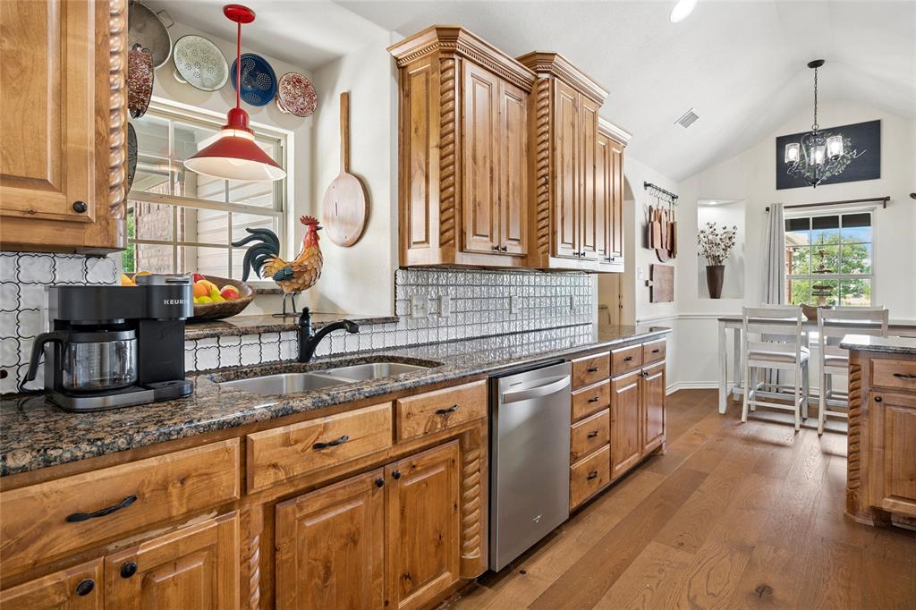 199 Newfield Lane Springtown, TX 76082 - Photo 15 of 38 Kitchen featuring wooden cabinetry, granite countertops, a stainless steel dishwasher, and hardwood flooring