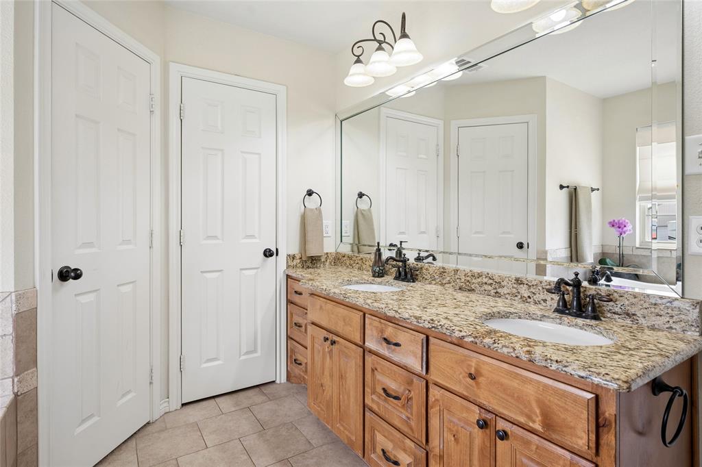 199 Newfield Lane Springtown, TX 76082 - Photo 21 of 38 Bathroom featuring a double vanity with light wood cabinetry, a granite countertop, and dual sinks