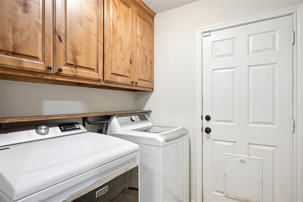 199 Newfield Lane Springtown, TX 76082 - Photo 26 of 38 Utility area featuring overhead wooden cabinetry and a light-colored door
