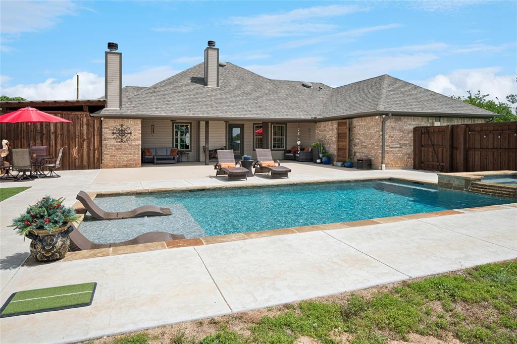 199 Newfield Lane Springtown, TX 76082 - Photo 29 of 38 The property features a spacious backyard with a large swimming pool and an adjacent hot tub