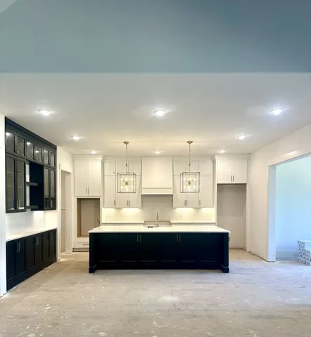 a large kitchen with a large counter top stainless steel appliances and cabinets