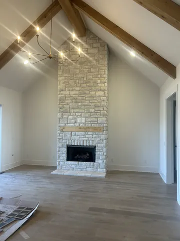 a view of empty room with wooden floor and fireplace