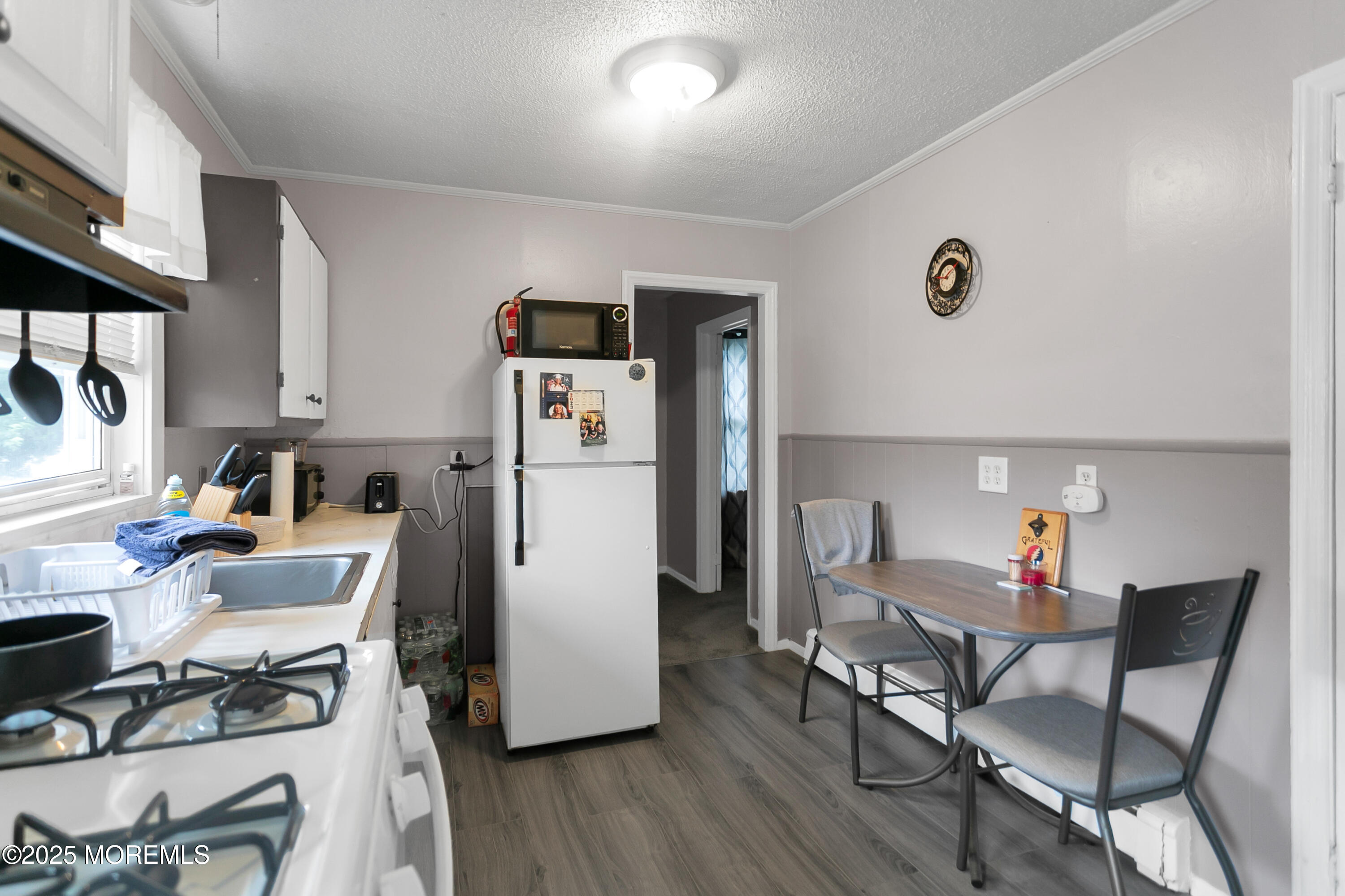 289 Port Monmouth Road North Middletown, NJ 07748 - Photo 32 of 37 a kitchen with stainless steel appliances a refrigerator a stove a dining table and chairs with wooden floor