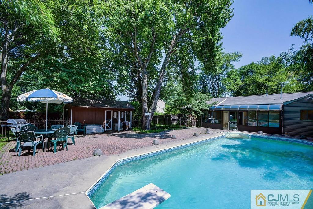 85 Kendall Road Kendall Park, NJ 08824 - Photo 22 of 25 a view of a patio with table and chairs under an umbrella