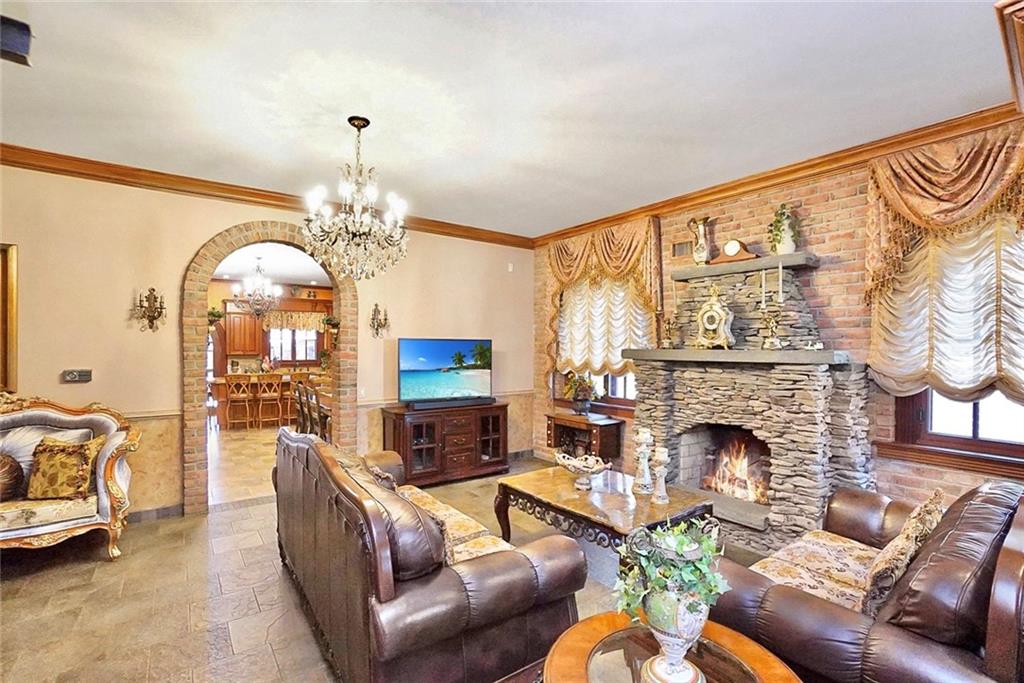 1406 73rd Street Brooklyn, NY 11228 - Photo 13 of 42 a living room with furniture a fireplace and a chandelier