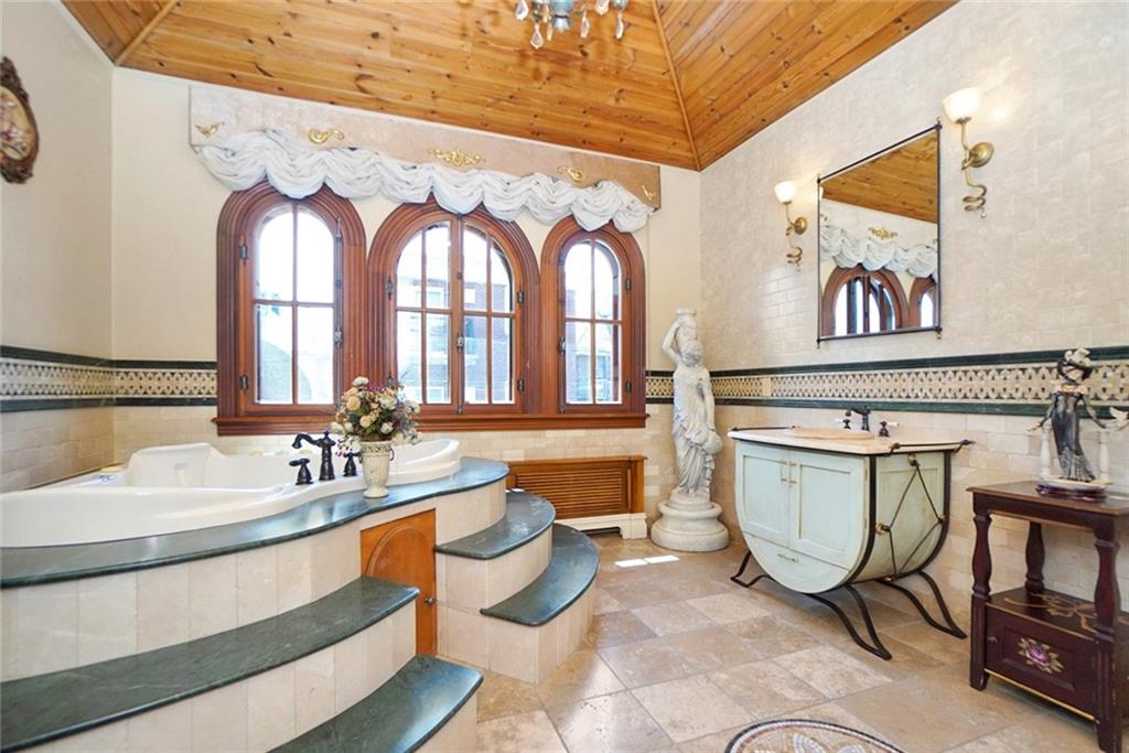 1406 73rd Street Brooklyn, NY 11228 - Photo 22 of 42 a bathroom with a sink mirror vanity and a bathtub