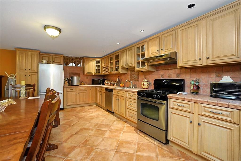 1406 73rd Street Brooklyn, NY 11228 - Photo 39 of 42 a kitchen with stainless steel appliances granite countertop a stove a sink dishwasher and a refrigerator