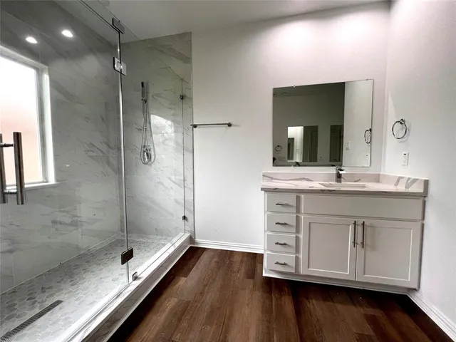 a bathroom with a double vanity sink mirror and shower