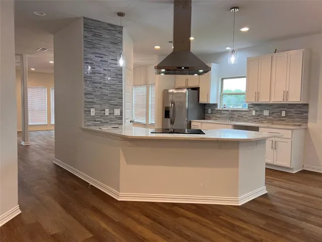 a kitchen with kitchen island stainless steel appliances a sink and a stove