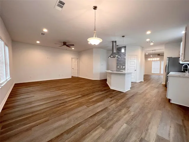 a view of a kitchen with stove and wooden floor
