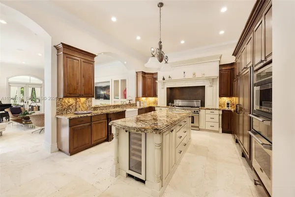 a large kitchen with stainless steel appliances granite countertop a stove oven and a refrigerator