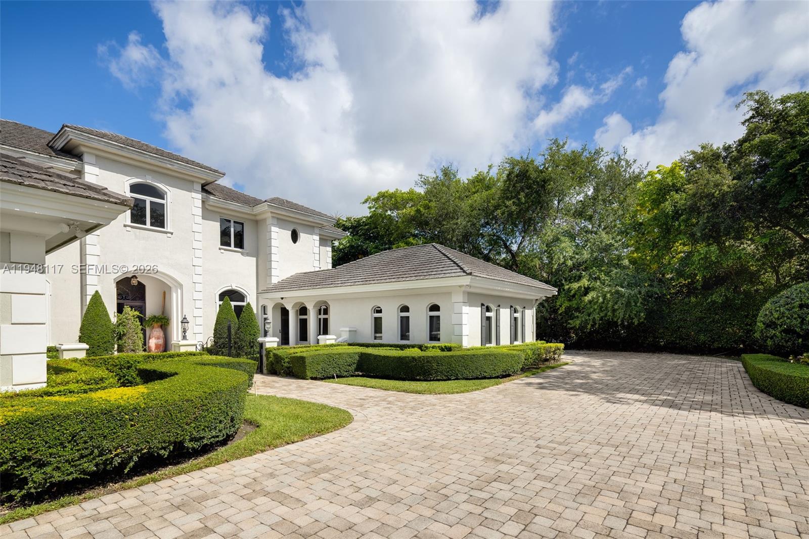 8252 School House Road Miami, FL 33143 - Photo 30 of 43 a front view of a house with a yard and trees
