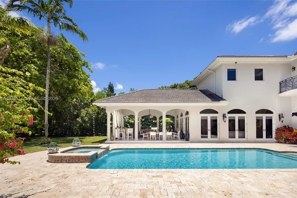 a view of house with garden and swimming pool
