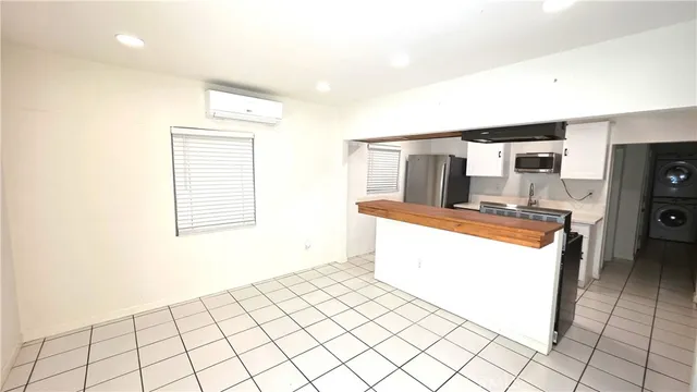 a kitchen with stainless steel appliances kitchen island granite countertop a refrigerator and a stove top oven