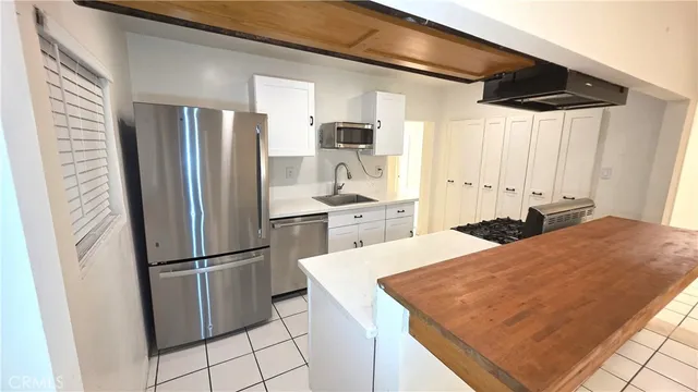 a large kitchen with a refrigerator a sink and dishwasher