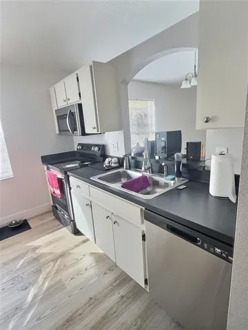 a kitchen with stainless steel appliances a sink dishwasher stove refrigerator and microwave