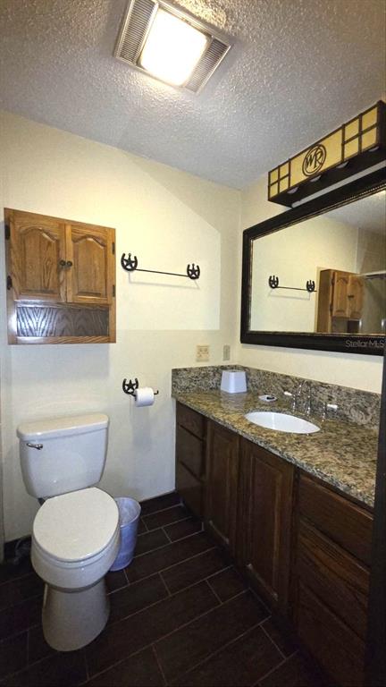 454 Cottage Circle, Unit 454 River Ranch, FL 33867 - Photo 16 of 27 a bathroom with a granite countertop toilet sink and mirror