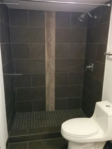 a bathroom with a toilet and a shower