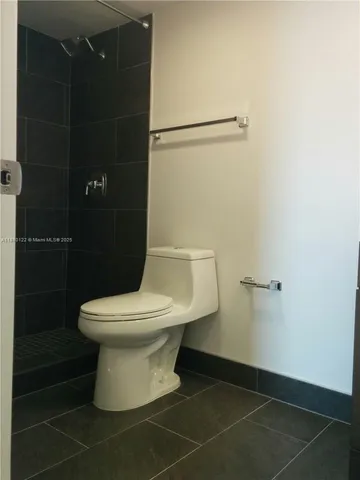 a white toilet sitting next to a shower