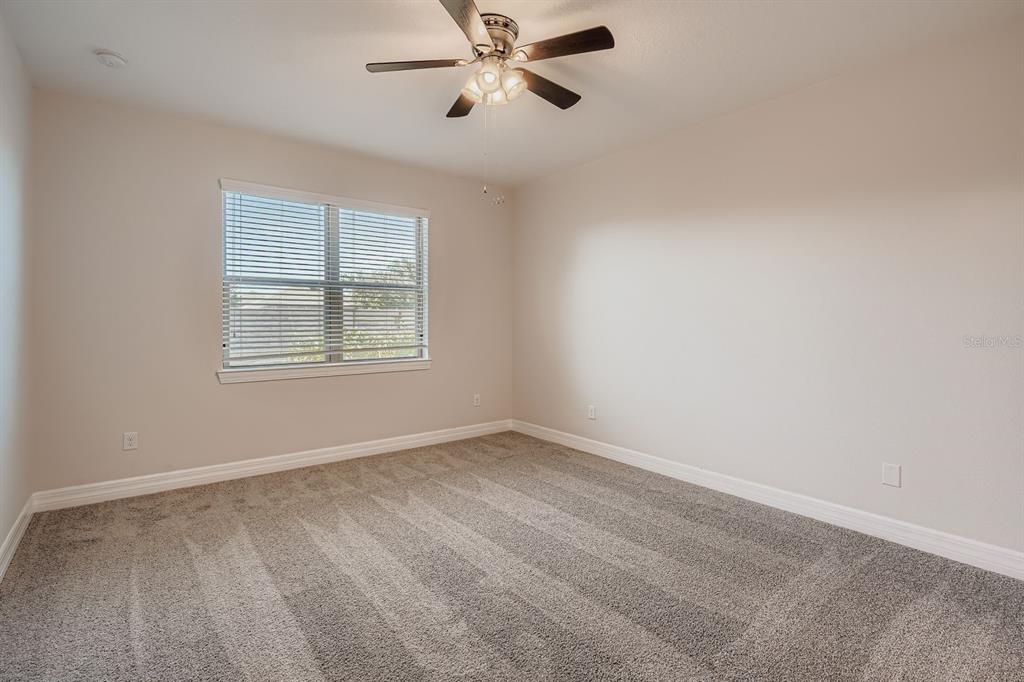 16355 Treasure Point Drive Wimauma, FL 33598 - Photo 15 of 28 an empty room with windows and fan