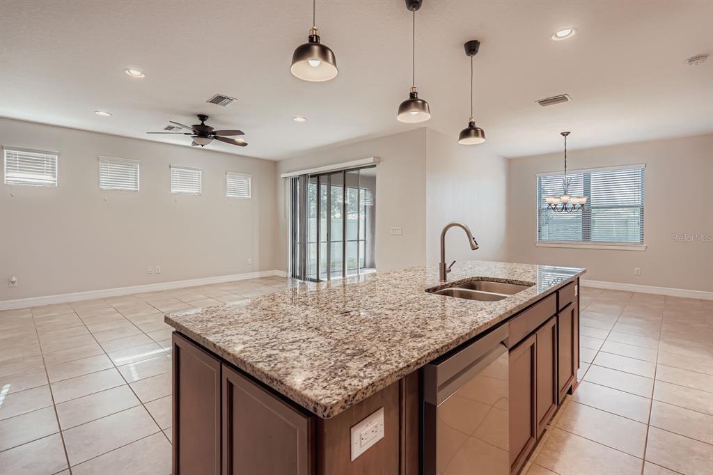 16355 Treasure Point Drive Wimauma, FL 33598 - Photo 10 of 28 a kitchen with center island chandelier and wooden floor