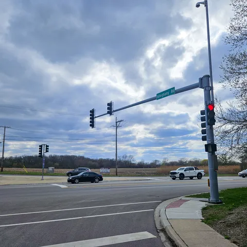 a view of a city street with a car parked on the road
