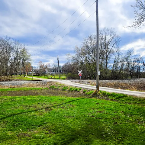 a view of a fountain in front of a building with large trees